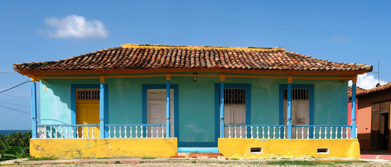 Charming cobblestone street lined with colorful, vintage buildings showcasing Cuban colonial architecture in Trinidad.