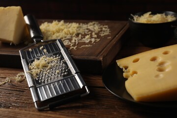 Different types of cheese and grater on wooden table, closeup - obrazy, fototapety, plakaty
