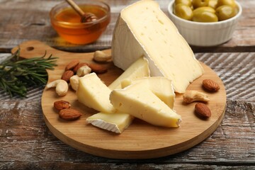 Tasty Camembert cheese with nuts on wooden table