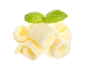 Pile of tasty butter curls and basil leaves isolated on white