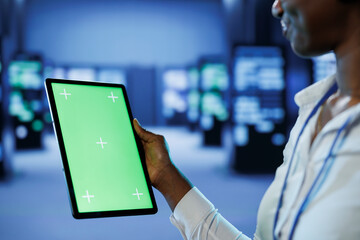 Experienced developer in server room uses green screen tablet to future proof network from...