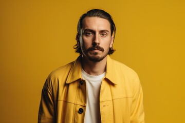 Obraz premium A man in a yellow jacket is standing in front of a yellow background