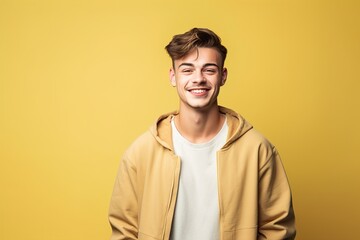 Fototapeta premium A young man is smiling and wearing a yellow jacket