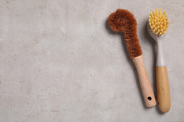 Cleaning brushes on light grey table, top view. Space for text