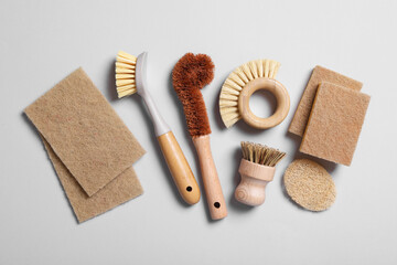 Cleaning brushes and sponges on grey background, flat lay
