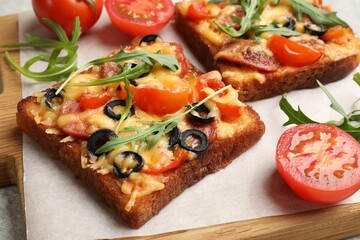 Tasty pizza toasts, fresh tomatoes and parsley on grey table, closeup