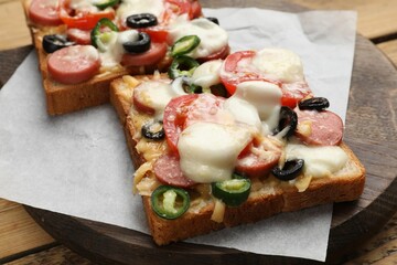 Tasty pizza toasts on wooden table, closeup
