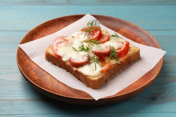 Tasty pizza toast with cheese, tomato and dill on light blue wooden table