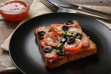Tasty pizza toast, sauce and cutlery on wooden table, closeup