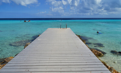 a pier on a beach on an island in the caribbean sea