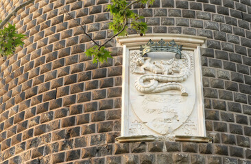 Damaged Coat of Arms of the Sforza Family in the stone wall of one of the towers at Sforza Castle (Castello Sforzesco) in Milan, Italy