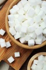 White sugar cubes on wooden table, top view