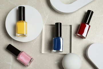Obraz premium Flat lay composition with bright nail polishes in bottles on light textured table