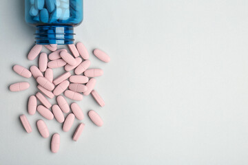 Vitamin pills and bottle on grey background, top view. Space for text