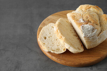 Freshly baked cut sourdough bread on grey table. Space for text