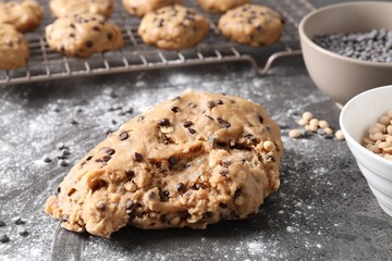 Raw dough with chocolate chips on grey table, closeup