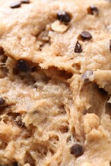 Raw dough with chocolate chips as background, closeup