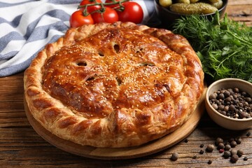 Tasty homemade pie and ingredients on wooden table