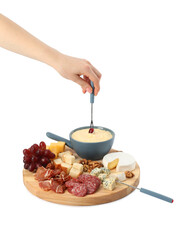 Woman dipping grape into fondue pot with melted cheese on white background, closeup