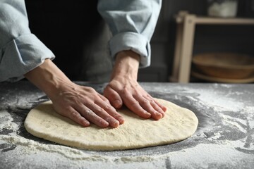 Woman making pizza dough at table, closeup