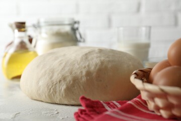 Raw dough and ingredients on white table