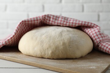 Fresh raw homemade dough on light wooden table