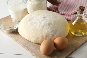 Raw dough and ingredients on white wooden table