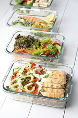 Healthy meal. Containers with different products on white wooden table