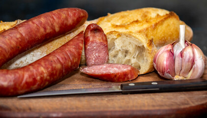 Rustic bread with salami and garlic on wooden board