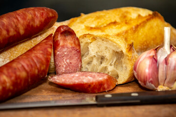Rustic bread with salami and garlic on wooden board