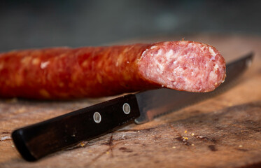 Rustic bread with salami and garlic on wooden board