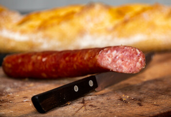 Rustic bread with salami and garlic on wooden board