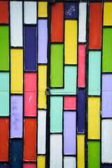 A stunning closeup of a colorful stained glass window featuring vibrant hues of magenta and...