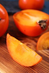 Delicious cut persimmon on wooden board, closeup