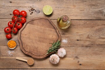 Cutting board, spices and products on wooden table, flat lay. Space for text