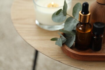Aromatherapy. Bottles of essential oil and eucalyptus leaves on wooden table