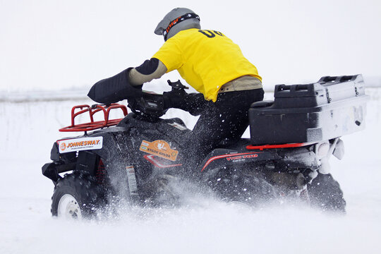 The quad bike (Kawasaki KVF 750) rides over snow track during Baja Kyiv-2010 Rally