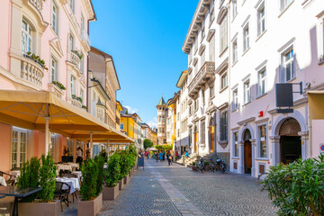A picturesque street of historic buildings with shops and sidewalk cafes in the old town district of Bolzano, Italy, in the South Tyrol region of Northern Italy.