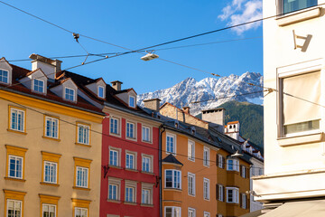 The snow capped Austrian Alps can be seen above the colorful medieval buildings in the historic old town center of Innsbruck, Austria.