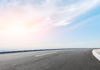 Modern highway cutting through the countryside under a clear blue sky