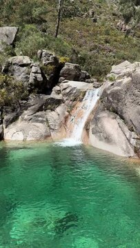 PAN SHOT The Po&ccedil;o Azul (Blue Well) is an idyllic lagoon with crystal-clear water that comes from the Landeira stream, which flows through granitic rocks to create a waterfall in the Peneda-Ger&ecirc;s Park.
