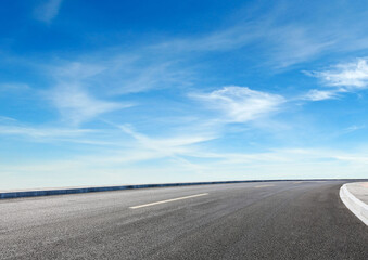 Modern highway cutting through Asian countryside under a clear blue sky