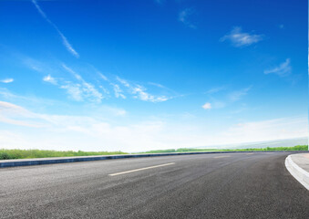 Naklejka premium Modern highway cutting through Asian countryside under a clear blue sky