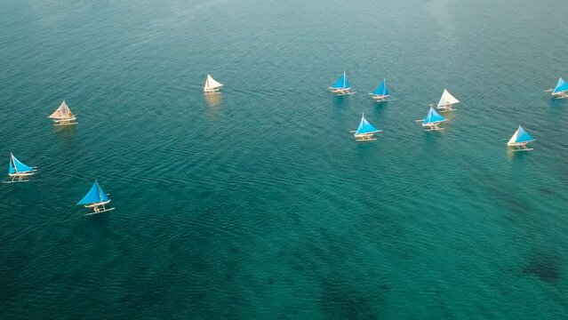 Top view of paraw sailing boats running over the turquoise water. Boracay, Philippines.