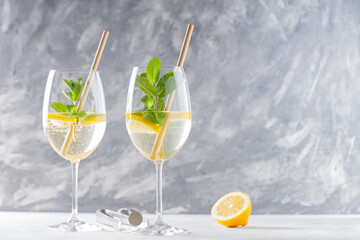Trendy Elderflower Hugo Spritz Cocktail with Lemon Slice on Gray Concrete Background, Copy Space