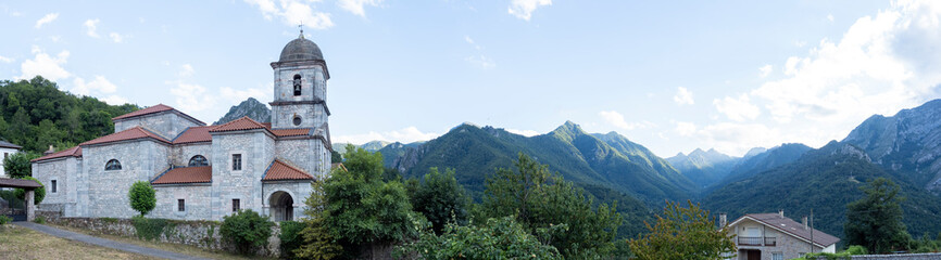Fototapeta premium Church of the Assumption of Our Lady with the picos de europa in the background, Oseja de Sajambre, Castilla y León Community, León Province, Spain.