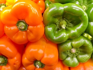 close-up of fresh orange and green peppers stacked on an organic producer's display
