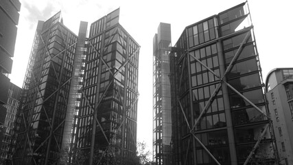 Monochrome image of skyscrapers under construction with scaffolding