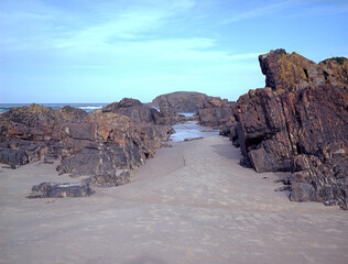 Sandy gap between the rocks on the beach. Medium format film (Kodak Ektar 100) shot scan (6x4.5 cm).