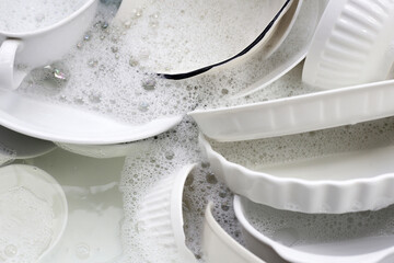 Dish washing, Dirty dishes soaking in kitchen sink.